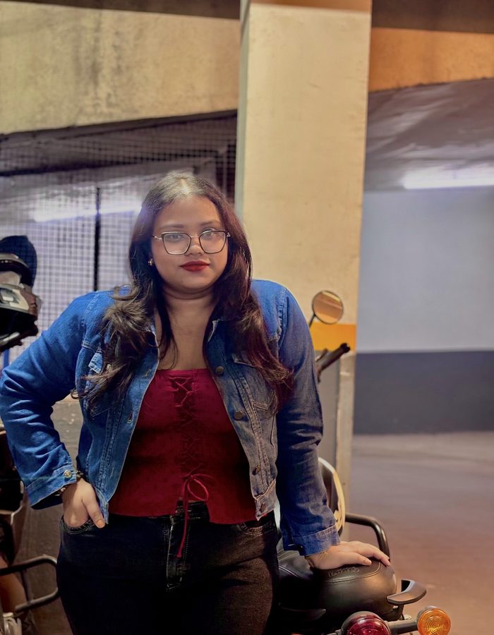 Payel in a denim jacket and red top