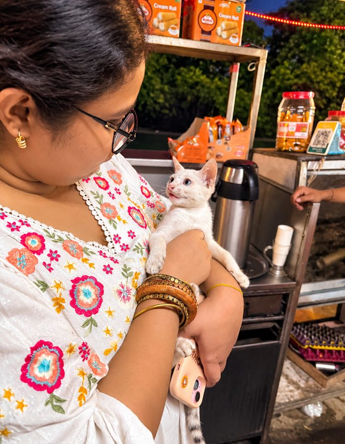 Payel holding a kitten at a night market